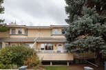 This charming townhouse features a stucco exterior and a tiled roof, offering a warm and inviting facade.