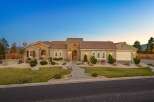 This stunning single-story home boasts a charming stucco exterior with stone accents and a classic tile roof.