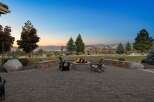 Enjoy breathtaking sunset views from this stunning backyard oasis, complete with a cozy fire pit and ample seating perfect for entertaining.