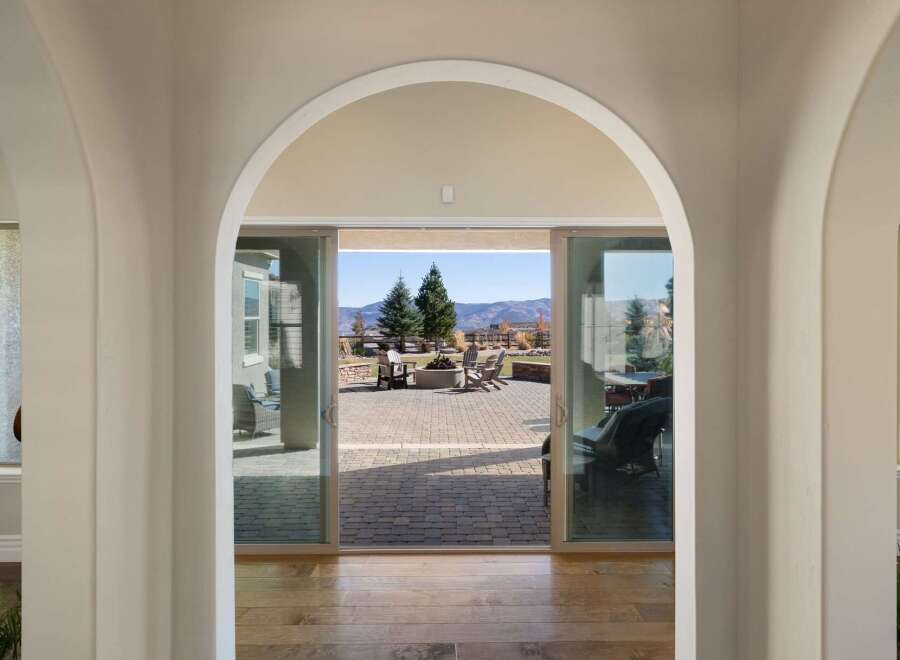Step through elegant arched doorways into a home that seamlessly blends indoor and outdoor living.