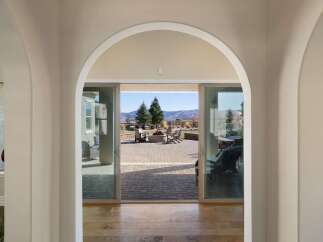 Step through elegant arched doorways into a home that seamlessly blends indoor and outdoor living.