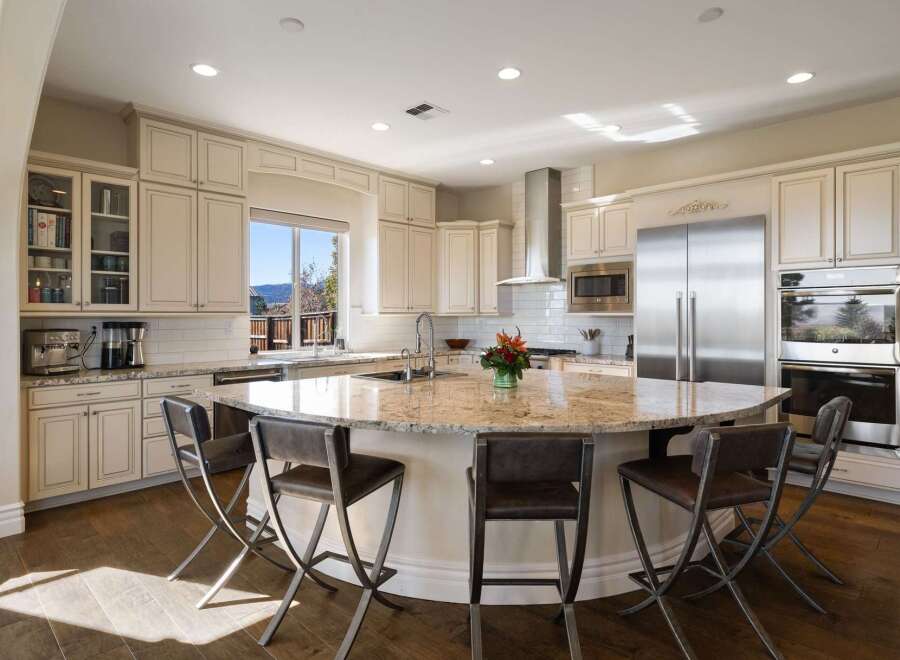 Experience luxury in this spacious kitchen, featuring a large granite island perfect for entertaining and a built-in coffee station.