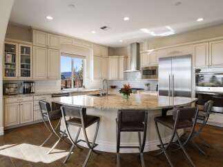 Experience luxury in this spacious kitchen, featuring a large granite island perfect for entertaining and a built-in coffee station.
