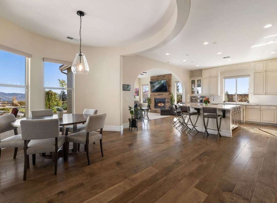 Experience open-concept living in this stunning home, featuring a spacious dining area with large windows overlooking breathtaking mountain views.