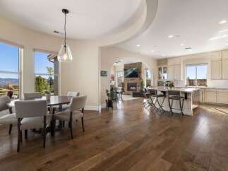 Experience open-concept living in this stunning home, featuring a spacious dining area with large windows overlooking breathtaking mountain views.