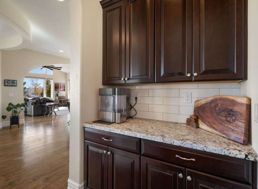 This spacious home features a modern kitchen area with dark wood cabinetry and granite countertops, perfect for entertaining.