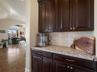 This spacious home features a modern kitchen area with dark wood cabinetry and granite countertops, perfect for entertaining.