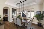 This elegant dining room features a spacious dark wood dining table surrounded by six upholstered chairs, perfect for hosting gatherings.