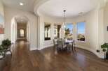 Step into this elegant home featuring a spacious hallway with arched doorways and rich hardwood floors.
