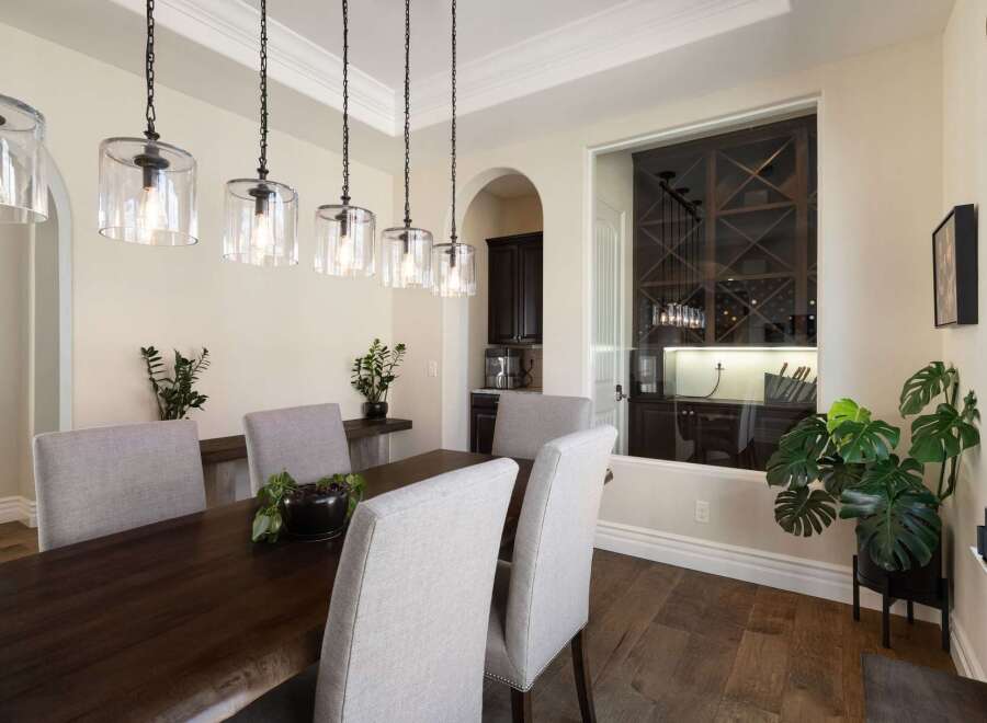 This elegant dining room features a dark wood live-edge dining table complemented by upholstered chairs.