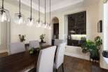 This elegant dining room features a dark wood live-edge dining table complemented by upholstered chairs.