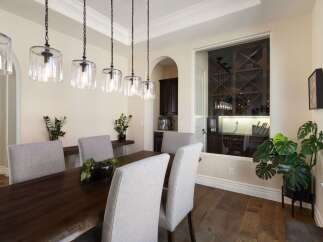 This elegant dining room features a dark wood live-edge dining table complemented by upholstered chairs.