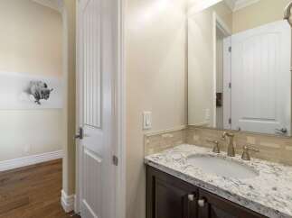 Step into this elegant bathroom featuring a granite countertop vanity with a modern undermount sink and brushed nickel fixtures.