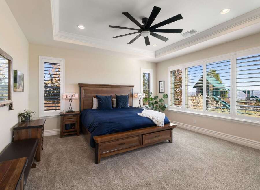 Experience luxury and comfort in this stunning master bedroom, featuring a spacious king-size bed with a rich navy blue comforter and plush pillows.