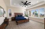 Experience luxury and comfort in this stunning master bedroom, featuring a spacious king-size bed with a rich navy blue comforter and plush pillows.