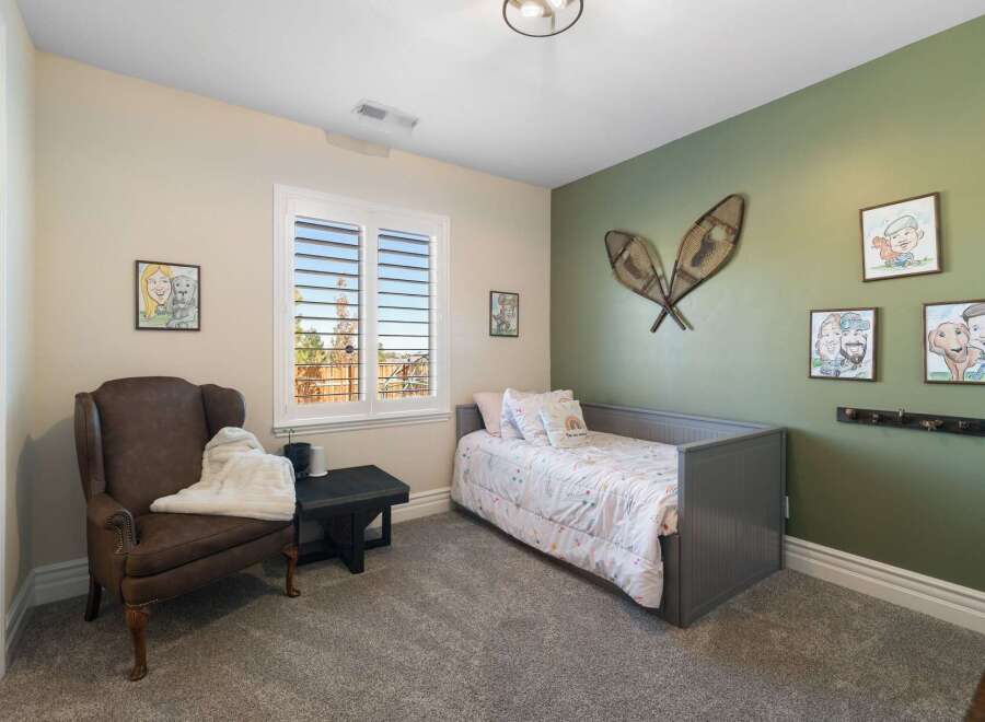 This charming bedroom features a cozy gray daybed adorned with a whimsical rainbow-themed comforter and pillows.