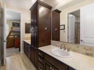 This spacious bathroom features a double vanity with dark wood cabinetry and a light-colored countertop, complemented by a tiled backsplash.