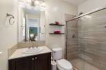 This modern bathroom features a sleek vanity with a white undermount sink and a tiled backsplash.
