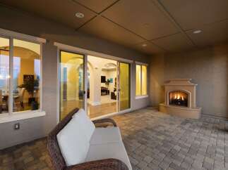 Experience luxurious outdoor living with this stunning patio featuring a cozy fireplace and comfortable seating.