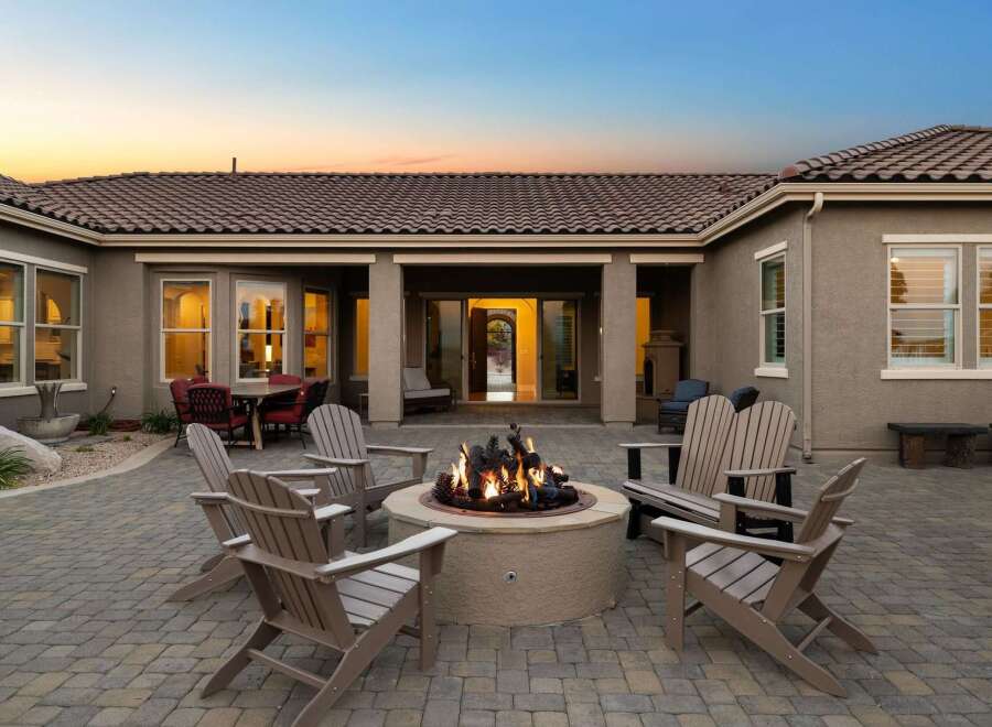 Experience luxurious outdoor living with this stunning patio featuring a central fire pit, perfect for cozy evenings.