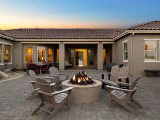 Experience luxurious outdoor living with this stunning patio featuring a central fire pit, perfect for cozy evenings.