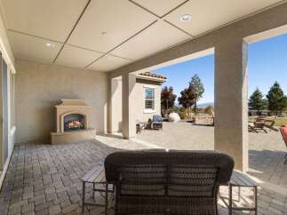Enjoy outdoor living with this spacious covered patio, featuring a cozy fireplace perfect for cooler evenings.