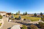 Enjoy outdoor living in this spacious backyard featuring a paved patio with comfortable seating and a built-in grill, perfect for entertaining.