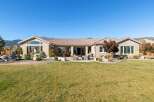 This stunning single-story home boasts a spacious backyard perfect for entertaining, featuring a paved patio with a fire pit and ample seating.