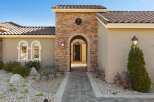 Step into luxury with this stunning home featuring a grand arched entryway adorned with natural stone.