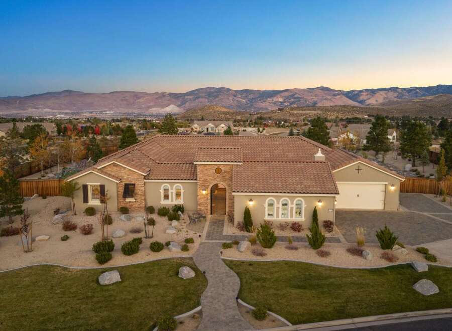 Experience luxury living in this stunning single-story home, boasting a tile roof and a charming stone-accented facade.