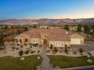 Experience luxury living in this stunning single-story home, boasting a tile roof and a charming stone-accented facade.