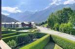 Experience breathtaking mountain views from this charming property, nestled amidst lush greenery and manicured hedges.