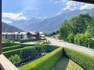 Experience breathtaking mountain views from this charming property, nestled amidst lush greenery and manicured hedges.
