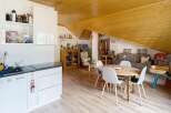Discover this charming attic apartment featuring a modern white kitchen with ample storage and a sleek countertop.