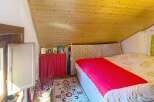 Experience cozy living in this charming attic bedroom, featuring a sloped wooden ceiling that adds warmth and character.