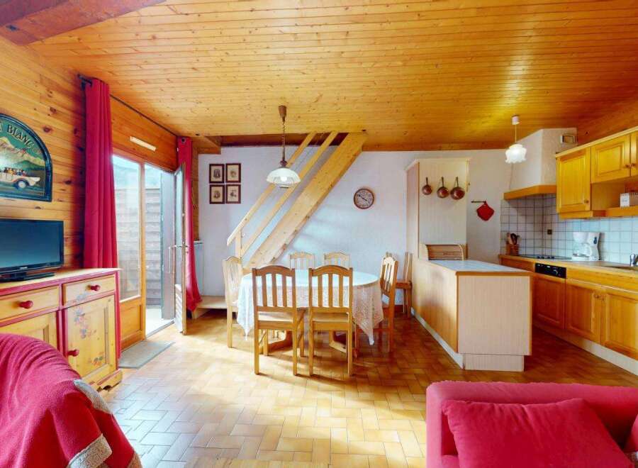 Experience the charm of this cozy mountain retreat, featuring a warm wooden interior and a spacious open-plan living area.