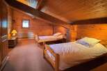 This charming attic bedroom features two cozy single beds, perfect for guests or family.