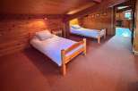 This charming attic bedroom features two cozy wooden twin beds, perfect for a family or guests.