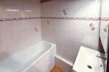 This bathroom features a pristine white bathtub and a modern sink, perfect for a relaxing soak or a quick refresh.