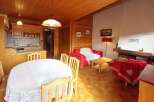 Experience cozy living in this charming wooden cabin, featuring a well-equipped kitchen and a spacious dining area perfect for family gatherings.