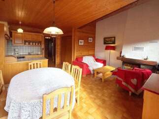 Experience cozy living in this charming wooden cabin, featuring a well-equipped kitchen and a spacious dining area perfect for family gatherings.