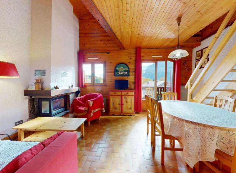 Experience cozy living in this charming mountain retreat, featuring a rustic wooden interior and a welcoming fireplace.