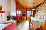 Experience cozy living in this charming mountain retreat, featuring a rustic wooden interior and a welcoming fireplace.
