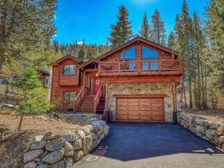 Experience mountain living in this stunning wooden lodge-style home, nestled amongst tall pine trees.
