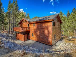Nestled amidst tall pine trees, this charming wooden cabin offers a serene mountain retreat.