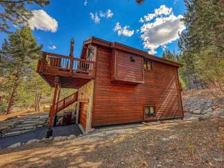 Experience mountain living in this charming wooden cabin, featuring a spacious deck perfect for enjoying the crisp air and scenic views.