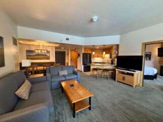 Experience comfortable living in this spacious open-concept apartment, featuring a modern kitchen with ample cabinet space and a breakfast bar.