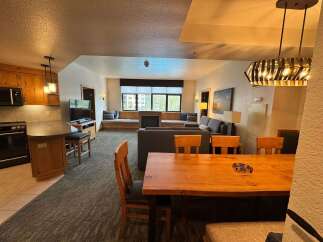 This spacious living area features a modern kitchen with ample cabinet space and a sleek black appliance suite.