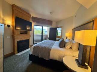 Experience ultimate comfort in this luxurious hotel room, featuring a cozy fireplace and a large flat-screen TV for your entertainment.
