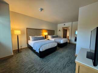 Experience comfort and style in this well-appointed hotel room, featuring two queen beds perfect for families or groups.